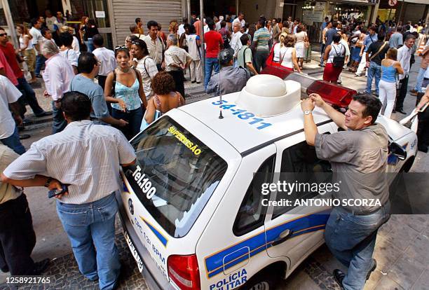 Police officers secure the area after a bomb threat proves to be a hoax in Rio De Janeiro, Brazil 28 February 2003. Funcionarios de un banco aguardan...