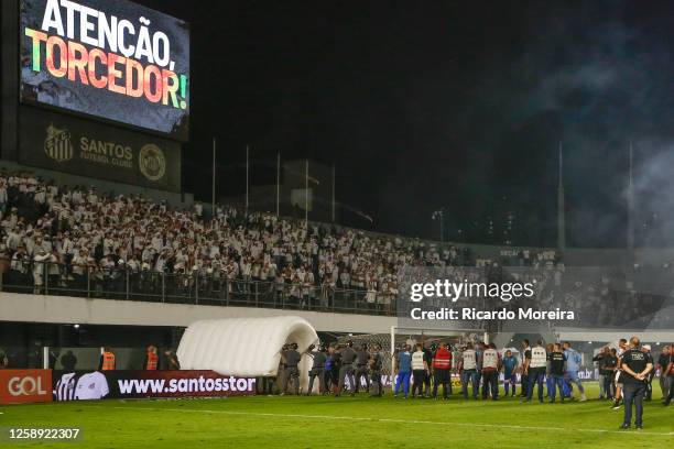 Fans of Santos throw firework bombs as players of Santos exit the field during the match between Santos and Corinthians as part of Brasileirao Series...