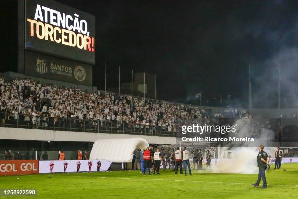 Fans of Santos throw firework bombs on the field during the match between Santos and Corinthians as part of Brasileirao Series A 2023 at Vila Belmiro...
