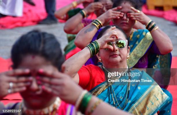 Women wearing traditional Nauvari sarees perform yoga at the Gateway Of India on International Yoga Day on June 21, 2023 in Mumbai, India.