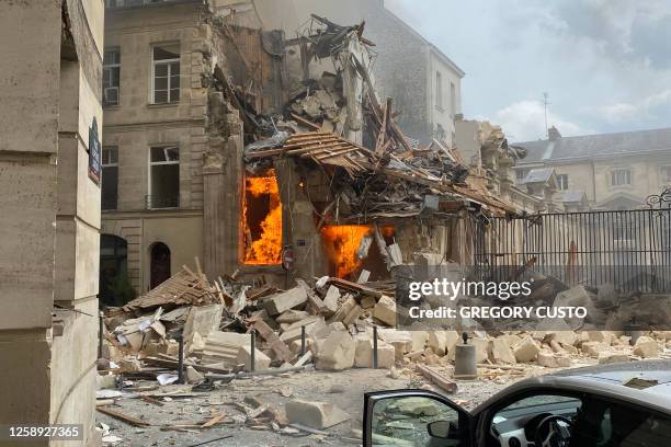 This photograph taken on June 21 shows the flames emerging from the destruction and rubble in the immediate aftermath of an explosion in a building...