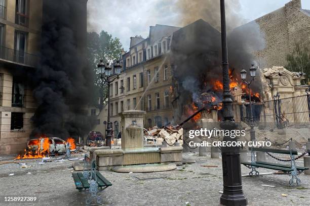 This photograph taken on June 21 shows the flames emerging from the destruction and rubble in the immediate aftermath of an explosion in a building...