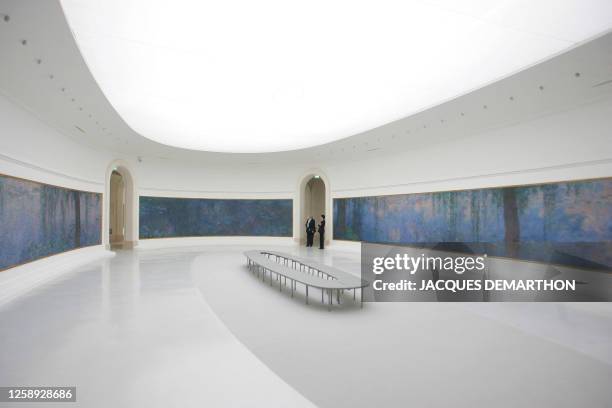 Men look at "les Nymphéas" of Claude Monet at the Museum 'L'Orangerie" in Paris, 02 May 2006, which will reopen 17 May 2006 after a six-years closure...