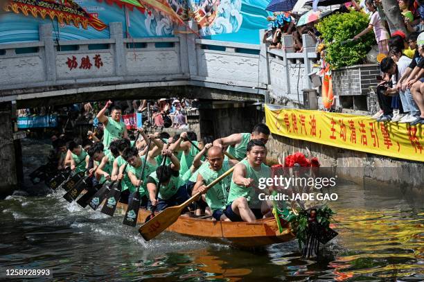 Competitors take part in dragon boat drifting races in a six-meter wide canal during the dragon boat festival in Foshan, in southern China's...