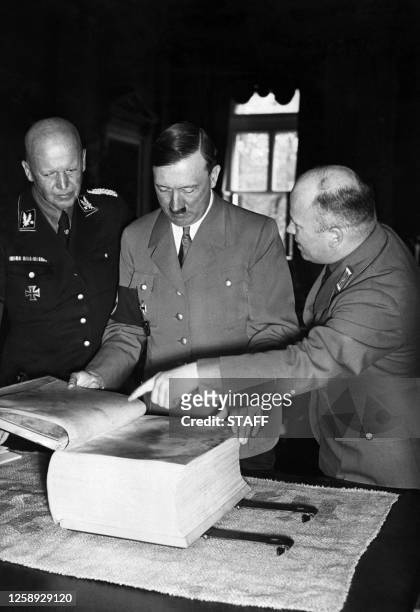 Photo non datée d'Adolf Hitler consultant une édition de "Mein Kampf" sur parchemin. "Mon Combat" est un ouvrage rédigé par Adolf Hitler entre 1923...
