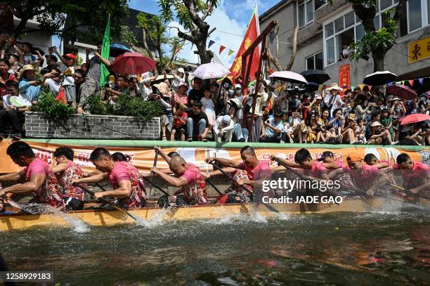 Competitors take part in dragon boat drifting races in a six-meter wide canal during the dragon boat festival in Foshan, in southern China's...