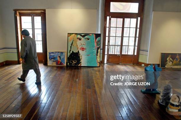 Un hombre acomoda un cuadro de la pintora Sicilia, antigua alumna de Frida Kahlo, en Ciudad de Mexico el 13 de abril de 2004. La exposicion se...