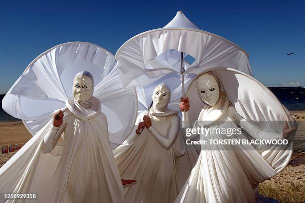 Performance art group Stretch Marks-1 dress like Greek goddesses while lining the route of the Olympic torch relay in Sydney, 04 June 2004, at the...