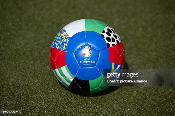 June 2023, Hamburg: A soccer ball with the UEFA EURO 2024 logo lies on an artificial turf pitch on the sidelines of a press conference on a UEFA EURO...