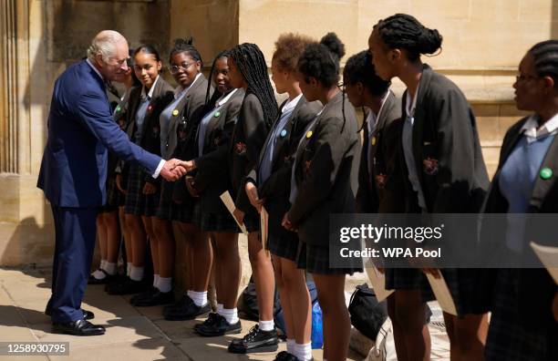 King Charles III meets with members of the choir from the St Martin-in-the-Fields High School for Girls, following a service at St George's Chapel,...