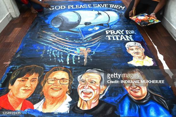 Art school students give final touches to a painting depicting five people aboard a submersible named Titan, that went missing near the wreck of the...