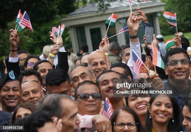 People wave US and Indian flags before an official welcoming ceremony at the White House for India's Prime Minister Narendra Modi, in Washington, DC,...