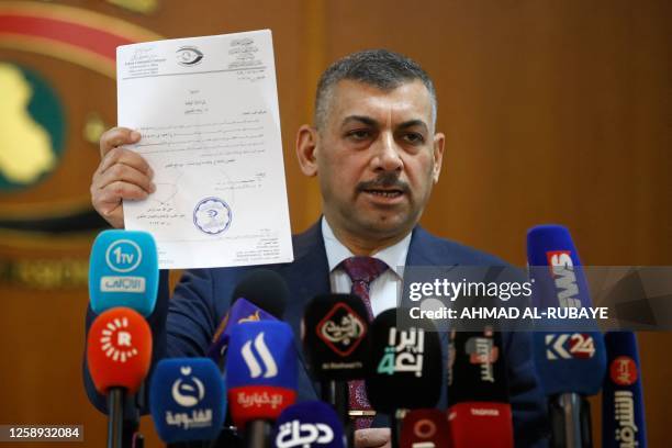 Judge Haider Hanoun, the head of Iraq's Integrity Comission, the government's anti-corruption agency, displays a document during a press conference...