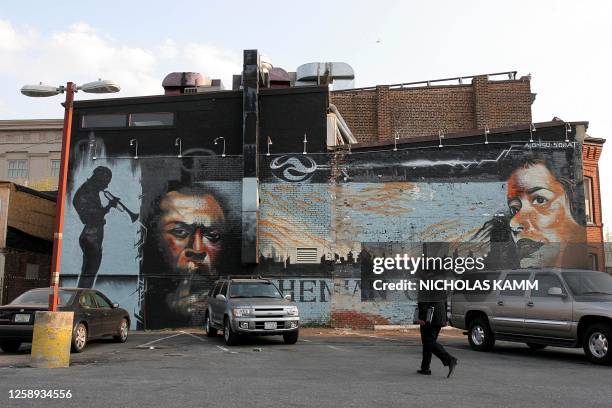 Man walks to his car in front of a mural showing jazz greats Miles Davis and Billie Holiday on the side of the Bohemian Cavern club on Washington's U...