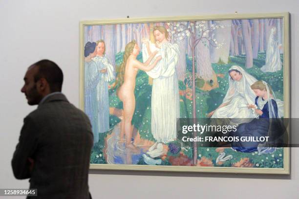 Une personne passe à côté du tableau Virginal printemps peint en 1899 par l'artiste Maurice Denis, le 27 octobre 2006 au Musée d'Orsay à Paris. Le...