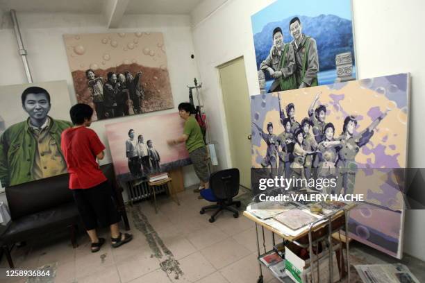Two Chinese artists are seen in their working space at the contemporary art compound called "798 Art District" or "Factory 798" in the Dashanzi...
