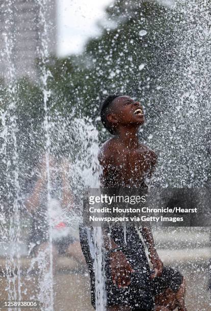 Jamari McDowell plays in the fountains with his family at Hermann Park, Tuesday, June 14 as temperatures reached into the mid-90s, in Houston.