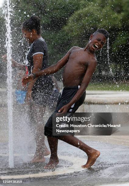 Jamari McDowell plays in the fountains with his family at Hermann Park, Tuesday, June 14 as temperatures reached into the mid-90s, in Houston.