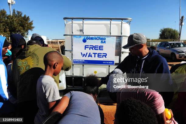 Residents queue for water delivered by a non-governmental organization at a community in Hammanskraal, South Africa, on Saturday, June 10, 2023....