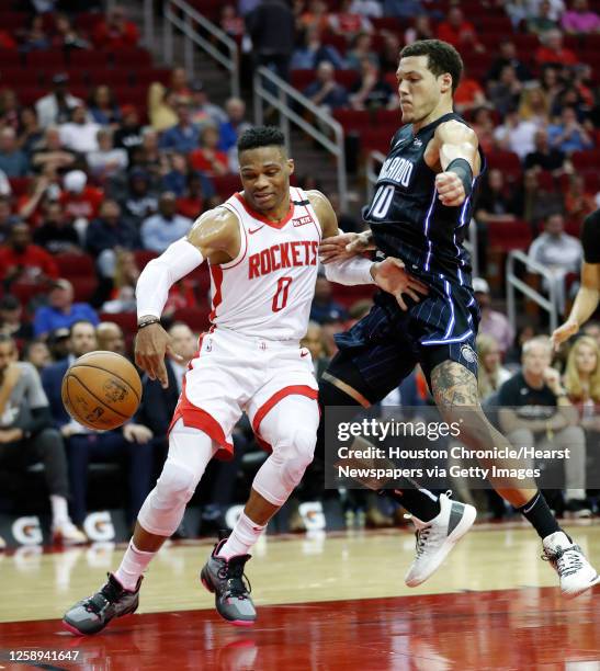 Houston Rockets guard Russell Westbrook works to recover a loose ball with Orlando Magic forward Aaron Gordon during the second half of an NBA...