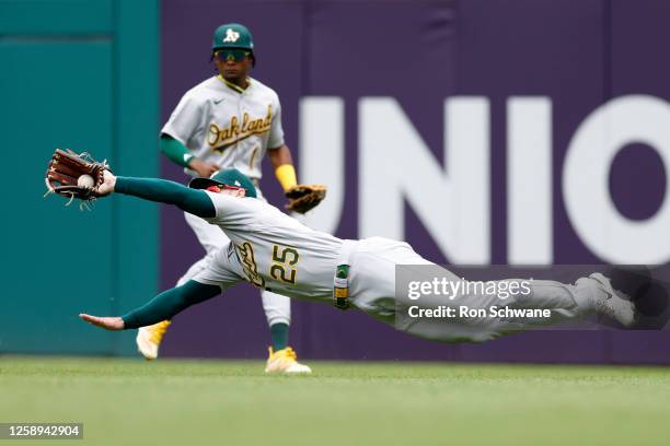 Brent Rooker of the Oakland Athletics makes a diving catch on a ball hit Josh Bell of the Cleveland Guardians during the second inning at Progressive...