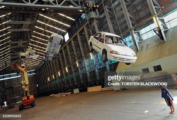 Engineers rig up eight dangling cars for Chinese artist Cai Guo-Qiang's Biennale installation 'Inopportune: Stage One' on Cockatoo Island in Sydney...