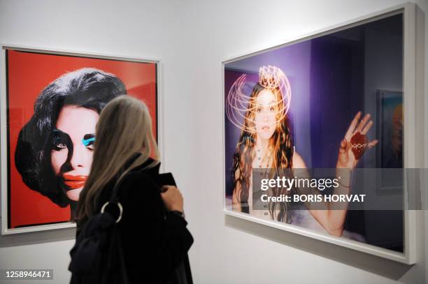 Person watches US photographer David LaChapelle's works "Amanda as Andy Warhol's Liz RED" and "Madonna" on February 5, 2009 at La Monnaie de Paris...