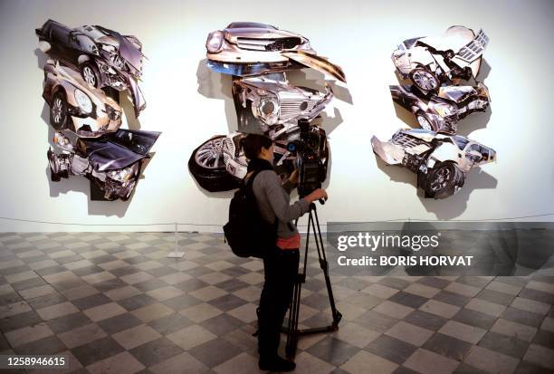 Person films US photographer David LaChapelle's work "The Crash" on February 5, 2009 at La Monnaie de Paris museum, during the opening of his...