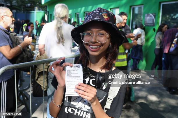 June 2023, Brazil, São Paulo: A young woman shows a tiket just bought at the Allianz Parque stadium for "The Eras Tour" by Taylor Swift. After riots...