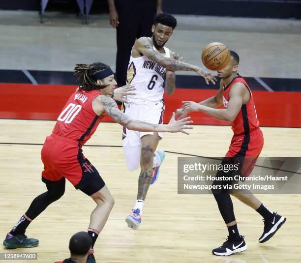 New Orleans Pelicans guard Nickeil Alexander-Walker passes the ball between Houston Rockets forward D.J. Wilson and guard Avery Bradley during the...