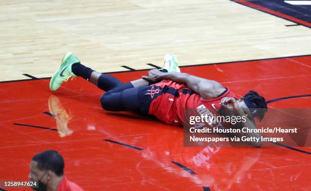 Houston Rockets forward Danuel House Jr. Lies on the ground grabbing his right ankle after falling to the floor during the first half of an NBA...