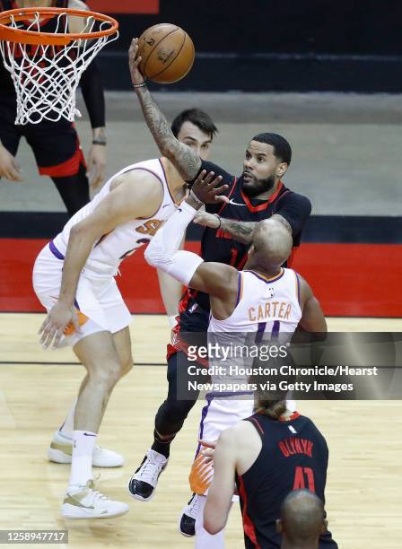 Houston Rockets guard D.J. Augustin goes up for a basket against Phoenix Suns guard Jevon Carter during the second quarter of an NBA basketball game...