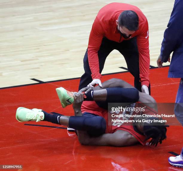 Houston Rockets forward Danuel House Jr. Lies on the ground grabbing his right ankle after falling to the floor during the first half of an NBA...