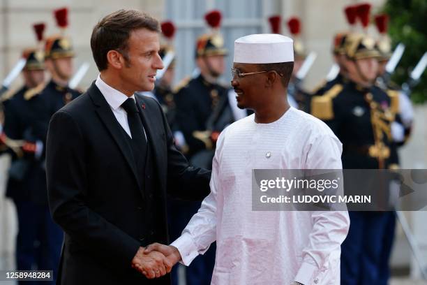 French President Emmanuel Macron greets transitional president of Chad Mahamat Idriss Deby upon arrival for an official dinner at the Elysee Palace,...