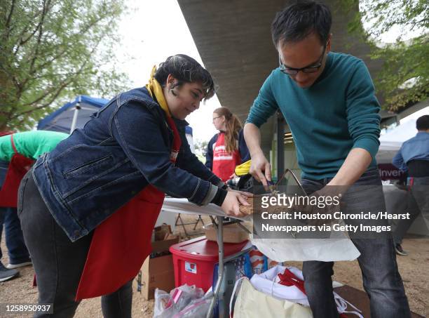 Lyndon Garcia and Marie Martinez, of Jackson&Ryan Architects, use a hacksaw to cut gingerbread as Architecture Center Houston hosted the 12th annual...