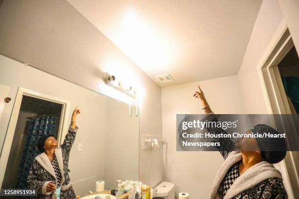 Rolesia Beal points out brown spots on her ceiling in her bathroom in her apartment at Coppertree Apartments on Thursday, Jan. 27, 2022 in Houston....