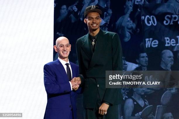 French basketball player Victor Wembanyama shakes hands with NBA commissioner Adam Silver after being picked by the San Antonio Spurs during the NBA...