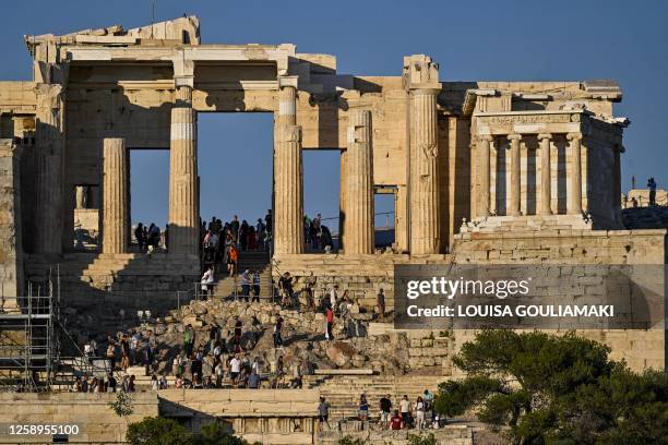 Tourists descent Propylaia, the ancient gate of the Acropolis archaeological site in Athens on June 21, 2023. "The wait and the amount of people that...