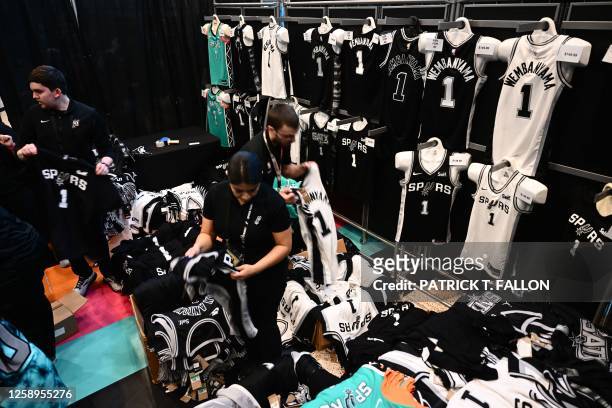 Employees fill orders for French basketball player Victor Wembanyama jerseys from fans after his selection as San Antonio Spurs's No. 1 pick during...
