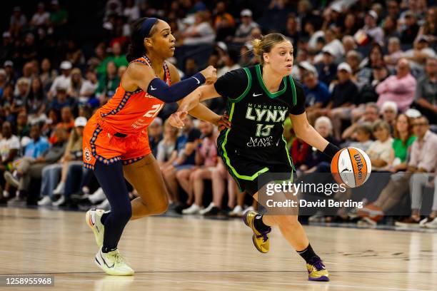 Rachel Banham of the Minnesota Lynx drives past DiJonai Carrington of the Connecticut Sun in the third quarter at Target Center on June 22, 2023 in...