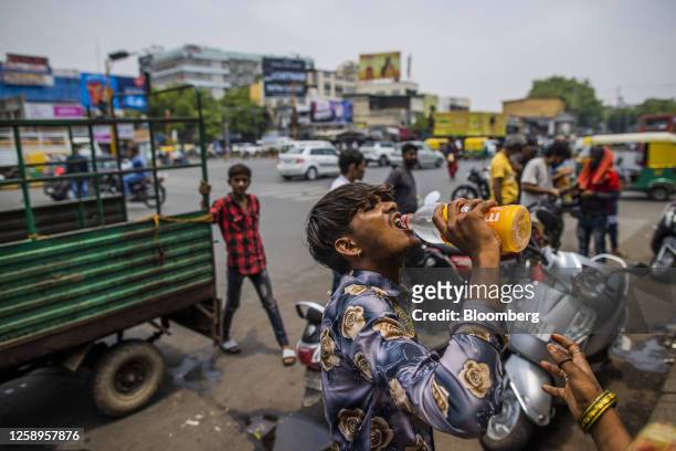 Man drinks water on the street in Ahmedabad, Gujarat, India, on Friday, May 5, 2023. Ahmedabad is an example of the patchwork coping mechanisms that...