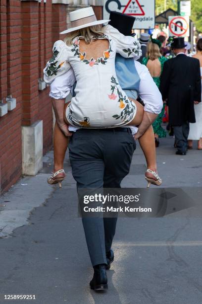 Racegoer is given a piggyback as she leaves Royal Ascot on Gold Cup Day on 22 June 2023 in Ascot, United Kingdom. Many spectators for Gold Cup Day,...