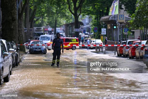 Fireman stands in a flooded street after storm "Lambert" hit the city of Dortmund, western Germany, on June 23, 2023.