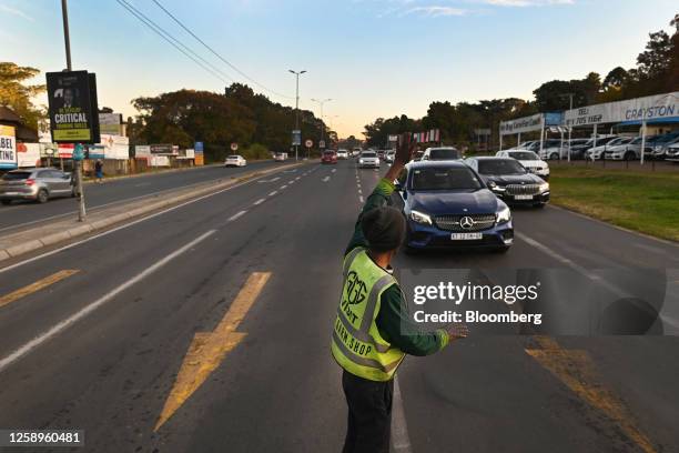 Self-appointed traffic controller directs traffic, to make money from driver tips, while traffic lights are down during a power shutdown, known...