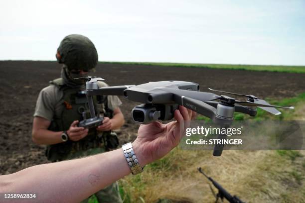 This photograph taken on June 23, 2023 shows Russian servicemen demonstrating an unmanned aerial vehicle used to find explosive ordnance during a...