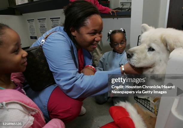 Nureka Chapman-Jacobs, kneeling center with two of her daughters, Amber Jacobs left, and Destiny Jacobs welcomes her dog Snow home Wednesday, Dec. 14...