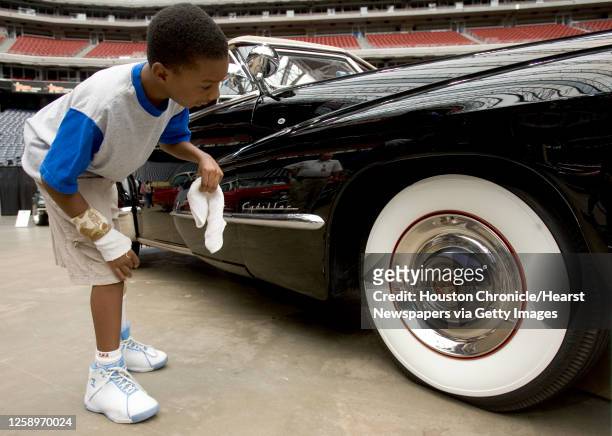 Kamal Lanig-Wade leans down to check out the wheel of a 1947 Cadillac convertible coupe during the Classy Chassis Vintage Auto Event Sunday, June 10...
