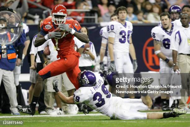 Houston wide receiver Jeron Harvey makes a first down reception over TCU linebacker Jason Phillips during the second quarter of the Texas Bowl...