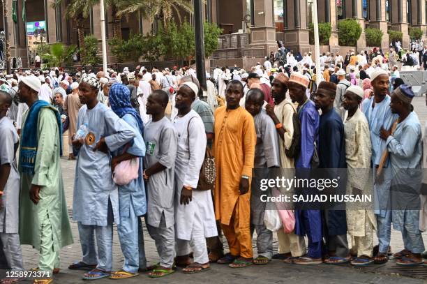 Pilgrims line up to receive food packages offered by the residents of Mecca, as Muslims from around the world arrive to attend the annual Hajj...