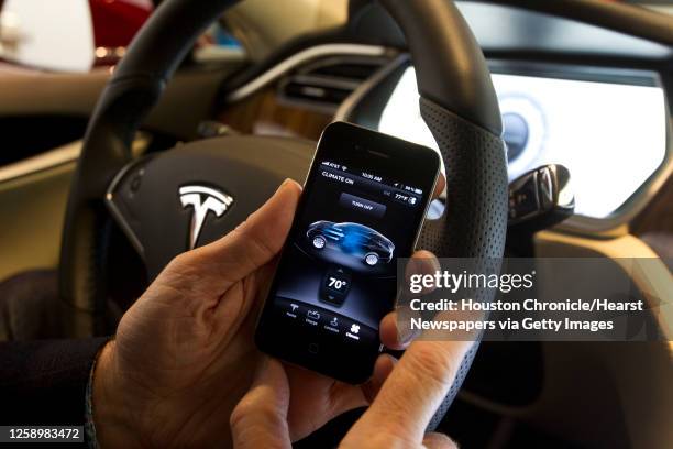 George Blankenship, vice president of worldwide sales for Tesla Motors, demonstrates the use of an iPhone to control features on the Model S at the...